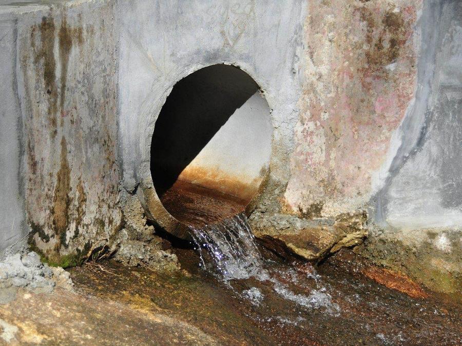Water flowing from a concrete sewer pipe